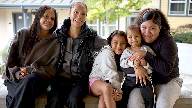 a group of people sitting outside hugging