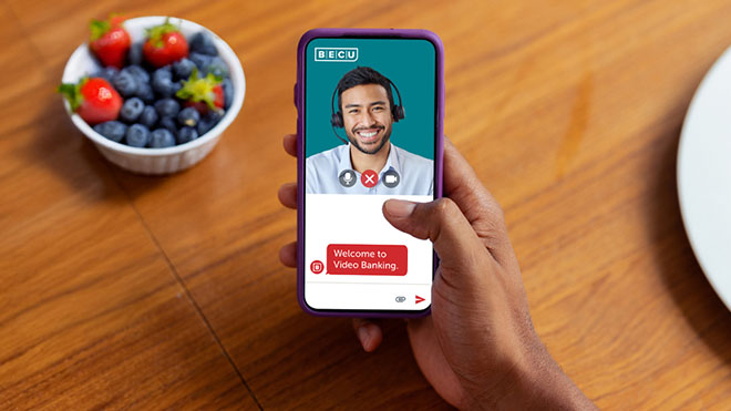 a mobile phone with a video banking representative on screen