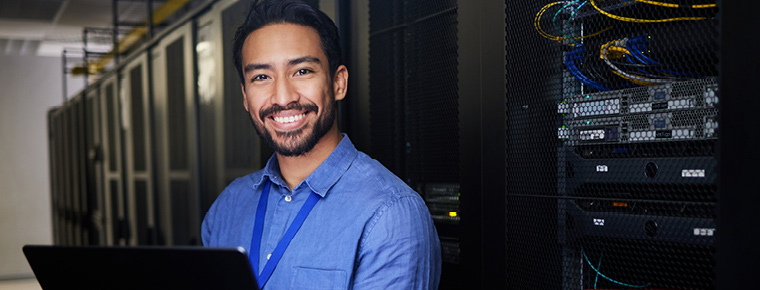 Smiling male technology employee holding laptop