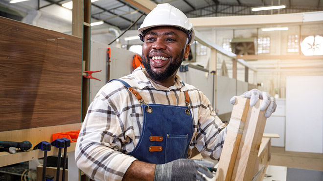 Smiling man in a warehouse.