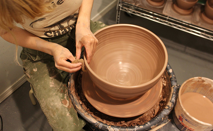 Woman making a bowl on a potters wheel